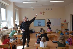 Policjantka ze strażakiem prowadzi spotkanie edukacyjno-profilaktyczne.