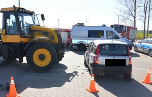 Na zdjęciu widoczny jest samochód fiat po prawej stronie (tył samochodu) oraz po lewej ciągnik rolniczy. W tle widoczne są dwa radiowozy oznakowane.