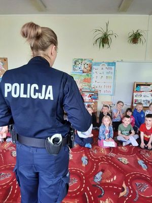 Policjantka prowadzi zajęcia z przedszkolakami.