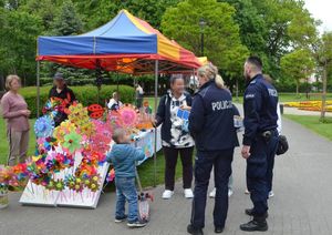 policjanci rozdają dzieciom w obecności ich opiekunów cukierki i odblaski