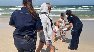 Policjantki rozdają opaski niezgubki dzieciom na plaży