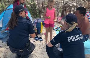 Policjantki rozdają opaski niezgubki dzieciom na plaży