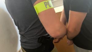 Policjant zakłada kajdanki zatrzymanemu