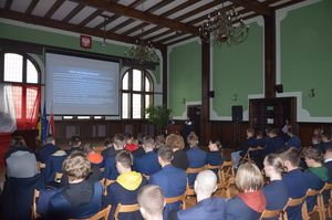 Policjantki prowadzą spotkanie, w tle widoczna prezentacja multimedialna.