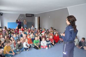 Policjantka prowadzi spotkanie, przed nią siedzą dzieci.