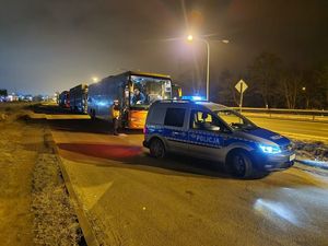 Kontrola autokaru, na przednim planie stoi policyjny radiowóz