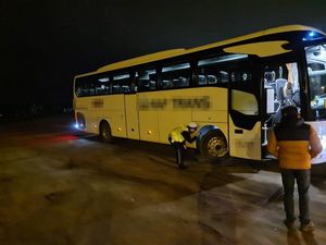 Kontrola autokaru, policjant sprawdza ogumienie w autobusie