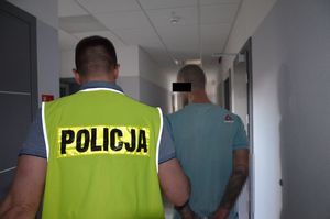 Policjant prowadzi zatrzymanego