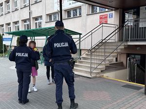 Policjanci przy szkole rozdają odblaski dzieciom