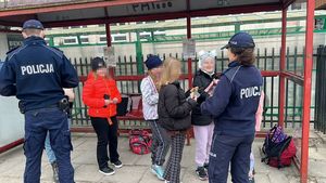 Policjanci rozdają odblaski dzieciom.