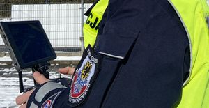 Policjant steruje dronem.