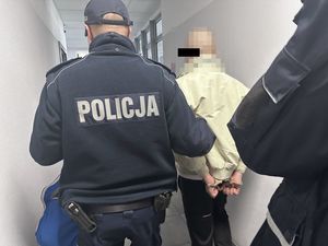 Policjanci prowadzą zatrzymanego.