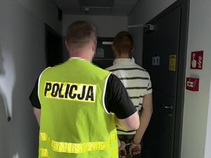 Policjant prowadzi zatrzymanego