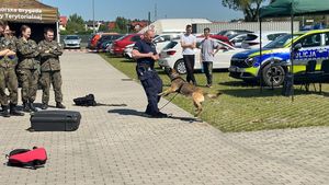 Policjant wykonuje pokaz tresury, uczniowie w mundurach się przyglądają