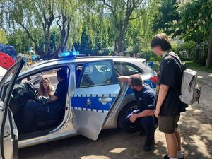 policjanci prezentują policyjny radiowóz