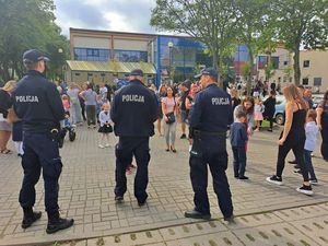 Policjanci przy szkole rozdają dzieciom odblaski.