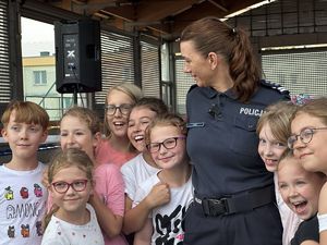 Policjantka otoczona dziećmi, które ją przytulają