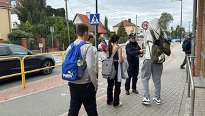 Policjantka rozdaje młodzieży szkolnej odblaski