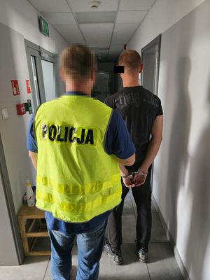 Policjant prowadzi zatrzymanego