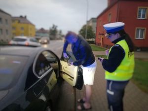 kierujący bmw stojąc obok policjantki zrywa z szyb pojazdu folię przyciemniającą