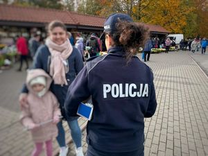 policjantka rozdaje odblaski pod cmentarzem