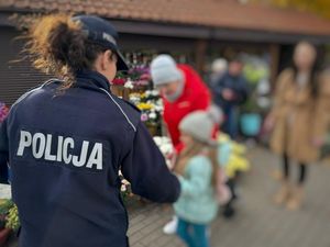 policjantka rozdaje odblaski pod cmentarzem