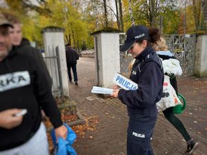 policjantka rozdaje odblaski pod cmentarzem