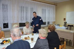 policjant rozdaje odblaski seniorom