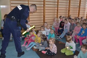 Policjant rozdaje odblaski dzieciom