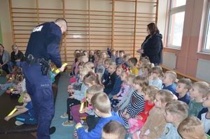 Policjant rozdaje odblaski dzieciom