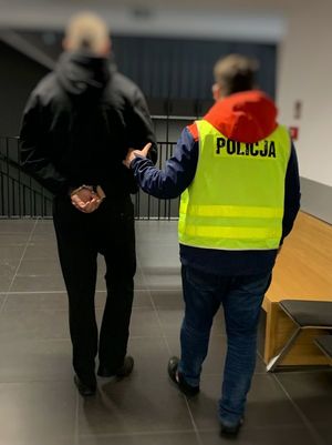 Policjant prowadzi zatrzymanego