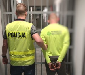 Policjant wprowadza zatrzymanego do celi.