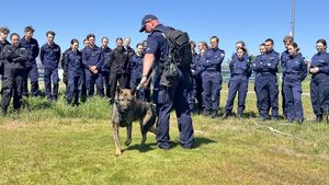 Policjant rozmawia z młodzieżą, przy nim stoi jego wierny czworonożny przyjaciel BOSS.