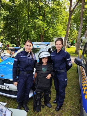 Policjantki pozują z dzieckiem na tle radiowozu