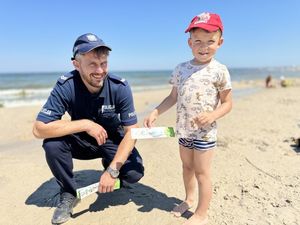 Policjant rozdaje dzieciom niezgubki - pozuje do zdjęcia