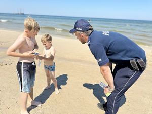 Policjant na plaży rozmawia z dziećmi