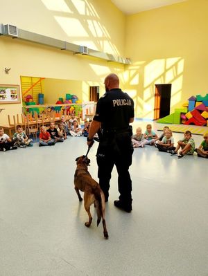 Policjant podczas spotkania z dziećmi prezentuje Lunę - psa policyjnego