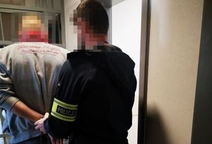 Policjant prowadzi zatrzymanego