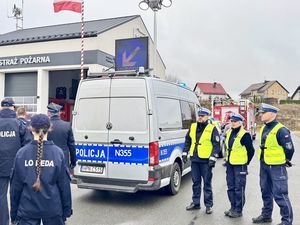 Policjanci stoją przy radiowozie