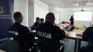 Policjanci siedzą na sali konferencyjnej i słuchają wykładu