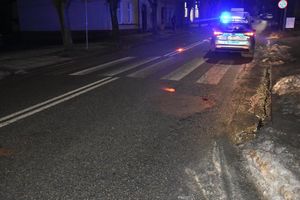 Na pierwszym planie przejście dla pieszych, radiowóz i w tle nieznacznie widoczny samochód który brał udział w zdarzeniu.