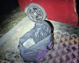 Worek z narkotykami leży na płytach przy samochodzie bmw w kolorze czerwonym