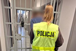 policjantka prowadzi zatrzymanego