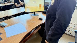 Policjantka prowadzi spotkanie i wyszukuje w Internecie na stronie doboru do Policji informacji, którą ma wyświetlić na dużym ekranie.