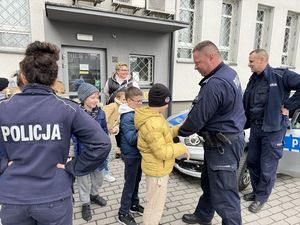 Dzielnicowi biorą aktywny udział w spotkaniu i prezentują radiowóz oraz kajdanki