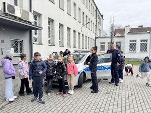 Dzielnicowi biorą aktywny udział w spotkaniu i prezentują radiowóz oraz kajdanki