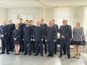 Zdjęcie stojących policjantów i pracowników biorących udział w uroczystości