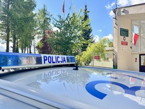 Dach radiowozu i w tle budynek szkoły, w którym odbywały się wybory