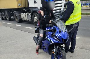 Policjant kontroluje motocyklistę.