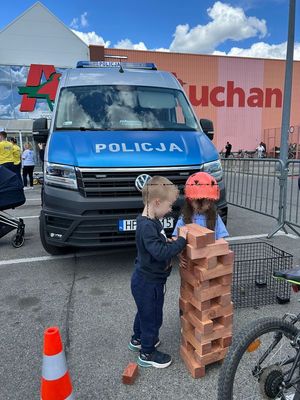 Dwoje dzieci w tle radiowóz.
